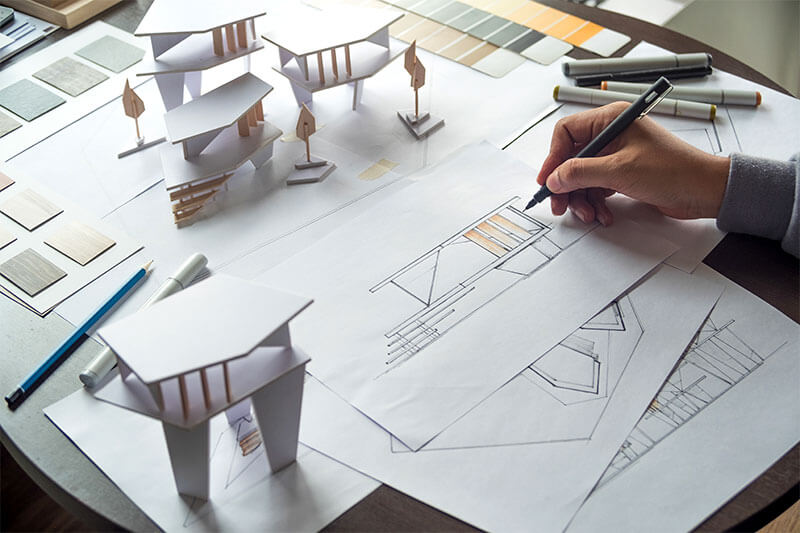Was ist eine Baufinanzierung? Ein Architekt, der ein Haus planz und zeichnet
